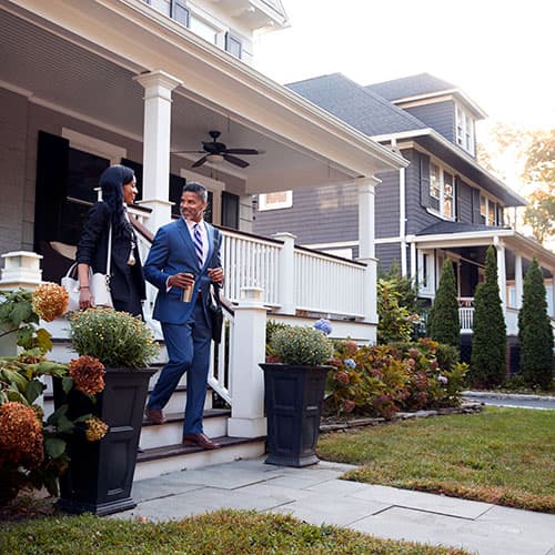 Agent walking out of a front door onto a house porch